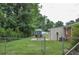 Fenced backyard featuring a patio dining set, storage shed, and lush greenery at 728 Tarpon Ct., Myrtle Beach, SC 29579