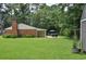 Spacious backyard featuring a patio with a table, grill, and a green lawn at 728 Tarpon Ct., Myrtle Beach, SC 29579