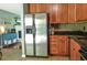 Bright kitchen features stainless steel refrigerator, tile floors, wood cabinets, and granite countertops at 728 Tarpon Ct., Myrtle Beach, SC 29579