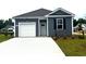 Charming single-story home with gray siding, attached garage, and a well-manicured lawn at 7469 Meadow Walk Loop, Loris, SC 29569