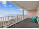 Beach view from a balcony with light pink siding and blue chairs at 817 S Ocean Blvd. # 201, North Myrtle Beach, SC 29582