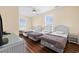 Neutral bedroom featuring three twin beds, wood floors, and a white wicker nightstand at 817 S Ocean Blvd. # 201, North Myrtle Beach, SC 29582
