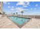 Outdoor pool area with travertine tile and a white picket fence at 817 S Ocean Blvd. # 201, North Myrtle Beach, SC 29582