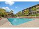Community pool with lounge chairs surrounded by well-maintained condos, palm trees, and beautiful blue skies at 9501 Shore Dr. # B-224, Myrtle Beach, SC 29572