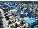 An aerial view of a home with a dark roof surrounded by water and neighboring properties at 112 Waterway Crossing Ct., Little River, SC 29566