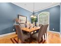 Inviting dining room with blue walls, hardwood floors, a decorative chandelier, and a large window at 1262 Limestone St., Murrells Inlet, SC 29576