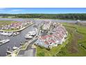 Aerial view showcasing waterfront condos with a marina, surrounded by lush greenery and waterways at 4396 Baldwin Ave. # 47, Little River, SC 29566