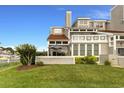 Rear exterior view of a home featuring a patio area, large windows, and well-maintained landscaping at 4396 Baldwin Ave. # 47, Little River, SC 29566