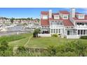 Rear exterior of a condo featuring a lawn and a marina with boats in the background at 4396 Baldwin Ave. # 47, Little River, SC 29566