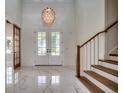 Bright foyer with white marble floors, elegant lighting, and a staircase with wooden accents at 5146 Middleton View Dr., Myrtle Beach, SC 29579