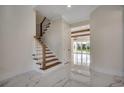 Bright hallway with staircase, white marble floors, and view into the bright living area at 5146 Middleton View Dr., Myrtle Beach, SC 29579