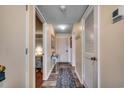 Inviting hallway with wood floors leads to bedrooms and the main entrance, thermostat and storage closet available at 5905 S Kings Hwy. # A 115, Myrtle Beach, SC 29575