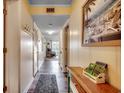 Hallway with wood floors and ocean art leads to the living room with a sunny view and beachy decor at 5905 S Kings Hwy. # A 115, Myrtle Beach, SC 29575