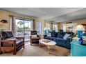 Relax in this sunny living room with comfortable seating, large windows, and a view of palm trees at 5905 S Kings Hwy. # A 115, Myrtle Beach, SC 29575