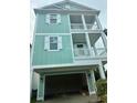 Striking 3-story home featuring dual balconies and a covered garage space at 1207 Salt Windy Way, North Myrtle Beach, SC 29582