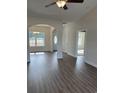 Bright open-concept living room featuring wood-look flooring, elegant archways, and a ceiling fan at Tbd5 Privetts Rd., Conway, SC 29526