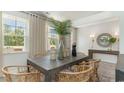 Bright dining room with wooden table, wicker chairs, and view of front yard at 120 Fair Meadow Ct., Loris, SC 29569