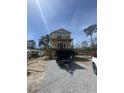 New construction home with a covered porch being built in a neighborhood surrounded by trees and blue skies at 723 10Th Ave. S, Surfside Beach, SC 29575