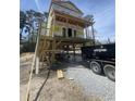 New construction home with a covered porch being built in a neighborhood with a dumpster at 723 10Th Ave. S, Surfside Beach, SC 29575