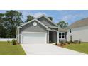 Well-manicured lawn highlights this gray single-Gathering home with attached two-car garage at 108 Fair Meadow Ct., Loris, SC 29569