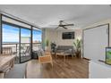Bright living room featuring tile floors, a ceiling fan, sliding glass doors leading to a balcony, and ocean views at 6804 N Ocean Blvd. # 1037, Myrtle Beach, SC 29572