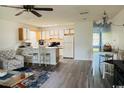 Open concept living room and kitchen with white cabinets, ceiling fan and modern flooring at 923 Fairwood Lakes Ln. # 23-Q, Myrtle Beach, SC 29588