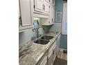 Kitchen featuring stainless steel double sink, faucet, backsplash, stone counters and cabinets at 9621 Shore Dr. # J-229, Myrtle Beach, SC 29572