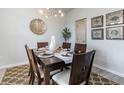 Staged dining room featuring a dark wood table, six chairs, modern lighting, and decorative wall art at 121 Fair Meadow Ct., Loris, SC 29569