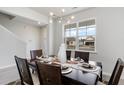 Staged dining room featuring a dark wood table, six chairs, modern lighting, and large windows at 121 Fair Meadow Ct., Loris, SC 29569