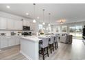 Open-concept kitchen with stainless steel appliances, quartz countertops, and an eat-in island at 121 Fair Meadow Ct., Loris, SC 29569