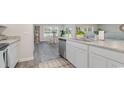 Well-lit kitchen featuring stainless steel dishwasher and sink, and views of the dining area at 119 Cambridge Dr., Tabor City, NC 28463