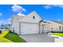 Charming home features neutral siding, a two-car garage, manicured landscaping, and a covered front porch at 3035 Deerberry Place, Longs, SC 29568