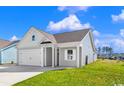 Well-maintained single-Gathering home featuring gray siding, a gray roof, and a two-car garage at 3035 Deerberry Place, Longs, SC 29568