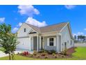 Side view of the home featuring well-manicured lawn, driveway and landscaping at 3035 Deerberry Place, Longs, SC 29568