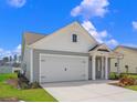 A view of the garage and driveway featuring attractive, light-colored siding at 3035 Deerberry Place, Longs, SC 29568