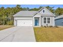 Charming single-story home featuring a bright blue door, gray siding, and a well-maintained front yard at 397 Sun Colony Blvd., Longs, SC 29568
