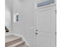 Bright entryway featuring a white front door, small window, and carpeted stairs at 233 Sandridgebury Dr. # 57, Little River, SC 29566