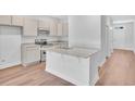 Bright, open kitchen with granite countertops, stainless appliances, and light wood floors at 233 Sandridgebury Dr. # 57, Little River, SC 29566