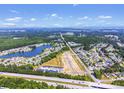 Wide aerial shot captures a community alongside a highway and serene lakeside at 293 Sandridgebury Dr. # 66, Little River, SC 29566