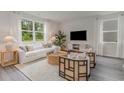 Bright living room featuring a comfy white couch and stylish armchairs at 1052 Black Lake Way, Conway, SC 29526