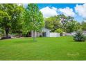 Expansive backyard features a lush lawn, mature trees, and a charming shed, creating a serene outdoor space at 660 Cardinal Ave. # 660, Myrtle Beach, SC 29577