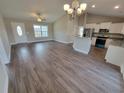 Inviting open-concept living space with wood floors, chandelier, and an airy atmosphere connecting to the kitchen at Tbd12 Privetts Rd., Conway, SC 29526