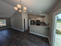 Bright living room open to kitchen, featuring modern chandelier and breakfast bar at Tbd20 Privetts Rd., Conway, SC 29526