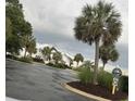 Community clubhouse and pool area featuring palm trees, lush landscaping, and ample parking at 1521 James Island Dr., North Myrtle Beach, SC 29582