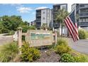 Exterior shows community signage with an American flag and well-maintained landscaping around the sign at 1500 Cenith Dr. # F103, North Myrtle Beach, SC 29582