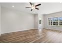 Bright, empty bedroom with hardwood flooring, white trim, ceiling fan and a view of the outdoors at 623 Carter Reid Ct., Longs, SC 29568