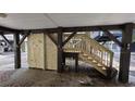 Under-house outdoor area with stairs and storage, partially enclosed with wood paneling at 6001 South Kings Hwy., Myrtle Beach, SC 29575