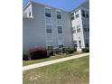 Exterior condo view featuring lush grass, shrubs, and a sidewalk at 2276 Essex Dr. # A, Myrtle Beach, SC 29575