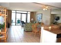 Open living area with a ceiling fan, balcony access, mirrored wall, and dining space at 501 S Ocean Blvd. # 1104, North Myrtle Beach, SC 29582