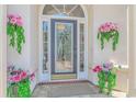 Close-up of the front door with decorative glass, framed by flower-filled planters at 5303 Pheasant Dr., North Myrtle Beach, SC 29582